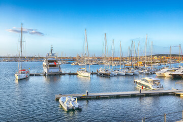 Obraz premium Unbelivable summer view of the Alghero Marina yacht port at the Gulf of Alghero with anchored sailboats.