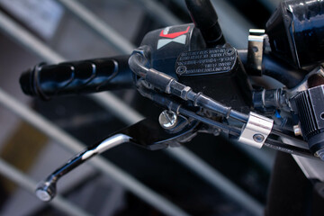 Close up of a motorcycle brake handlebar with detailed grip texture and lever, commonly used for braking control and riding safety