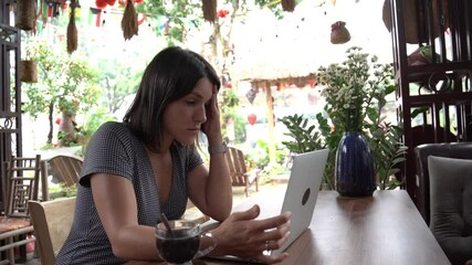 Professional woman finishing work, sipping coffee at cozy cafe table - Powered by Adobe