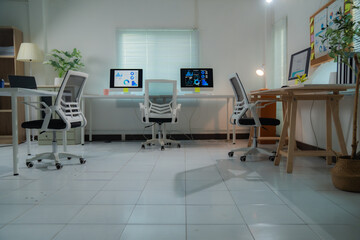 Empty contemporary office with computers displaying financial charts, suggesting a focus on data analysis and market trends in a professional setting
