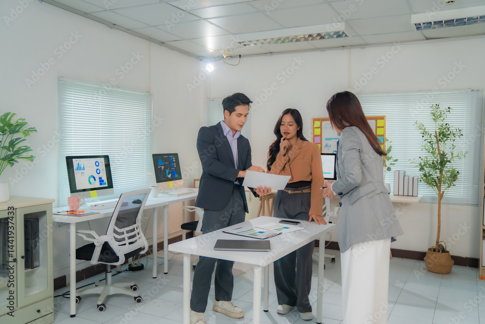 Poster marketing team discussing and analyzing marketing data charts using documents and computer in the of