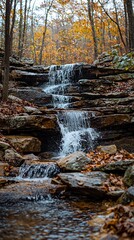 Autumn waterfall cascading over layered rocks in a forest