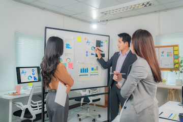 Business team analyzing financial charts and graphs while discussing company strategy and planning marketing operations during a presentation in a modern office