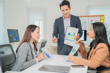 Business team working together, analyzing financial charts and discussing strategies for success in...