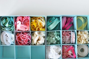 Colorful ribbons, cords and zippers in blue boxes on white background
