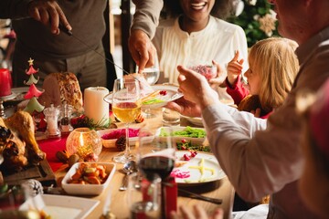 Festive family dinner with happy diverse group enjoy holiday meal. Diverse family group enjoy food and festive moments. Holiday dinner gathering, diverse people happy family enjoy holiday meal