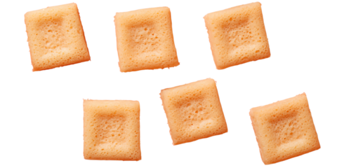Six square, golden, crunchy cereal pieces arranged in a scattered pattern.