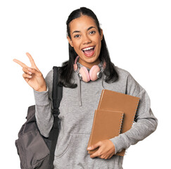 Young Filipino female student with books joyful and carefree showing a peace symbol with fingers.