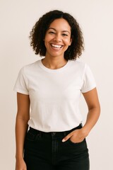 A joyful young woman wearing a white t-shirt and black jeans, smiling warmly at the camera.