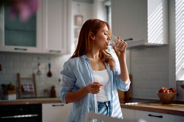 Mid adult woman enjoying in glass of fresh water.