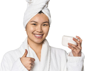 Chinese woman with moisturizer in robe smiling and raising thumb up