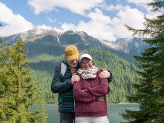 Carefree senior couple enjoying hiking day in mountain excursion expressing happiness and...