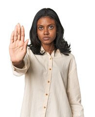 Portrait of a young Indian woman standing with outstretched hand showing stop sign, preventing you.
