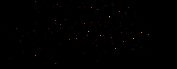 Panoramic blurred fire embers sparks on black background . Texture isolated overlays. Concept of particles, sparkles, flame and light.