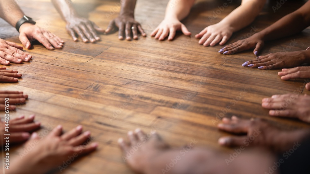 Poster diverse hands of various ethnicities on wooden floor. unity and teamwork shown by hands. hands of di