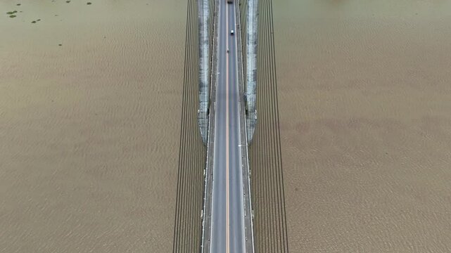 Pan up glides over the Macapagal Bridge bypassing Butuan City as it spans the Agusan River in Mindanao, Philippines.