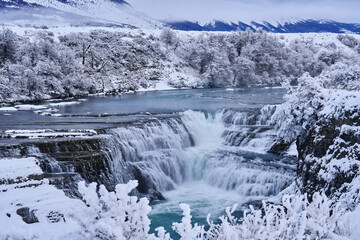 Cascadfa Rio Paine. Winter lanscape from Patagonia moutains with snow. Rio paine, Torres del Paine National Park, Chile. Twilight blue evening sky. Traveling in Chile,  hills in Torres del Paine NP.