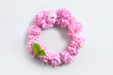 Pink hydrangea flowers as wreath on gray background. Mother's Day Greeting Card. View from above. Space for text.