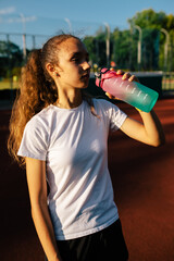 Teenage girl training at the stadium, doing track and field exercises, running and performing various athletic drills.