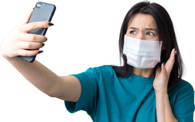 Portrait of a beautiful girl taking a selfie on a gray background wearing a medical mask.