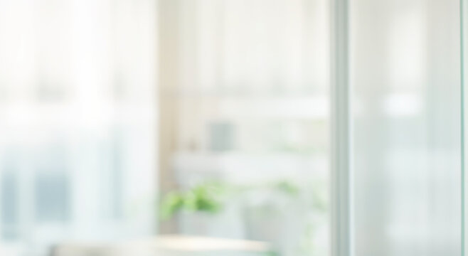 Blurred interior view through a window with sheer white curtains and soft light.