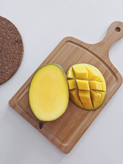 Fresh Ripe Mango on Wooden Cutting Board. Minimalist Flat Lay. Recipe ingredient