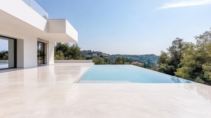 Fototapeta premium Modern minimalist villa terrace with an infinity swimming pool overlooking a green hilly landscape under a clear blue sky.