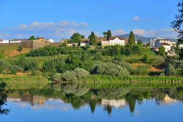 Landscape of the Rio Mino, natural border between Portugal and Spain, with buildings of Moncao reflected in the water