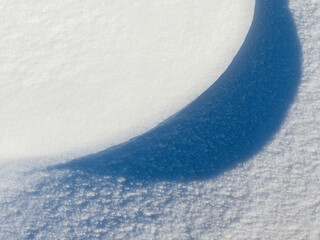 Beautiful winter background with snowy ground. Natural snow texture. Wind sculpted patterns on snow...