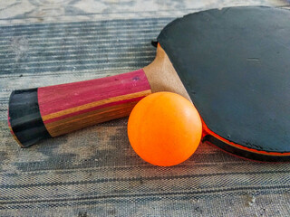 ping-pong ball and the racket on the grey table