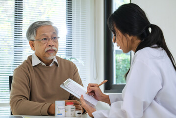 Obraz premium Doctor Writing Prescription for Elderly Patient During Clinic or Hospital Visit