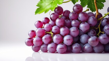 Fototapeta premium Foliage and red grape set against a white backdrop