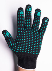 Black safety work glove with green rubber grip dots on white background