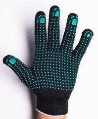 Black safety work glove with green rubber grip dots on white background