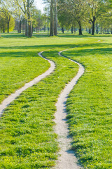 Fototapeta premium Two tracks in the grass of one of the urban parks in Milan, Italy, named 