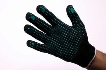 Black safety work glove with green rubber grip dots on white background