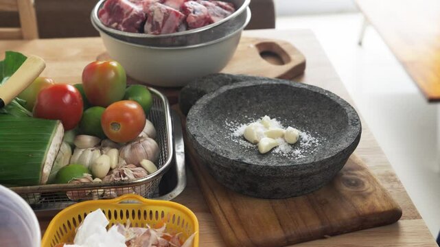 Close up of garlic sprinkled with salt before being crushed using a mortar and pestle