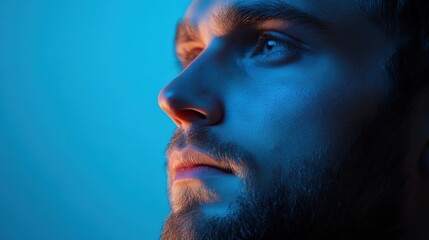 Obraz premium Man looks upward in blue light