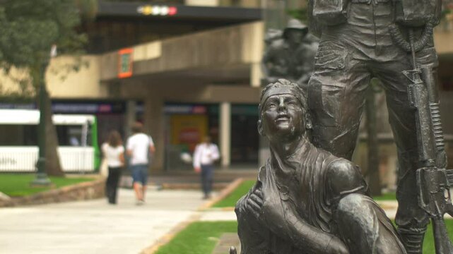 Solemn statue of an injured soldier aided by a comrade with a rifle in Anzac Square