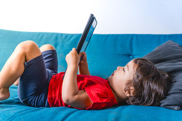 Baby toddler girl watching alone a tablet, screen time and screen addiction in children. Concept of children and technology and screen time
