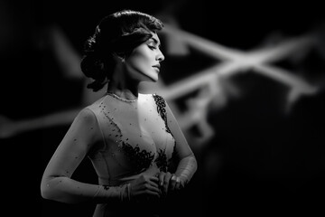 Monochrome fashion portrait of beautiful sensual woman with curly hair. Retro-themed black and white portrait with studio light, wave hair, and serene expression