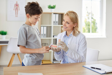 Fototapeta premium Young smiling woman stomatologist teaching cleaning teeth a little child boy patient for oral health in hospital. Professional dentist teaching how to use toothbrush in dental office.