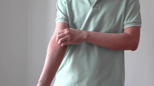 Young asian man itching and scratching on arm from allergic itchy dry skin eczema dermatitis insect bites