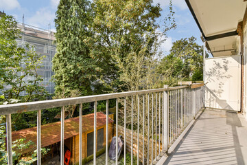 A serene balcony view featuring green trees and a well-maintained garden space, perfect for relaxation and enjoying nature's beauty.
