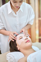 Female Esthetician Performing Facial Treatment on Woman in Spa