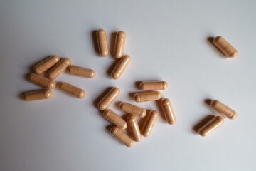 Numerous pink capsules of palmitoylethanolamide dietary supplement from above