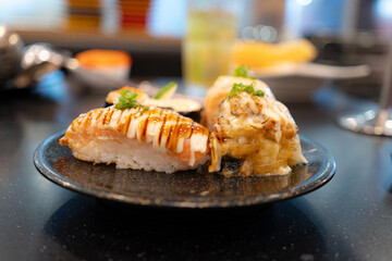 Japanese cuisine. Sushi set on a wooden plate over dark table background.