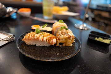 Japanese cuisine. Sushi set on a wooden plate over dark table background.