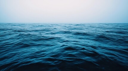 Obraz premium A tranquil expanse of blue water under a pale sky