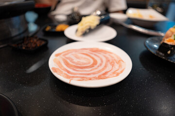becon slices in white plate for hot pot from above in flat lay food concept.